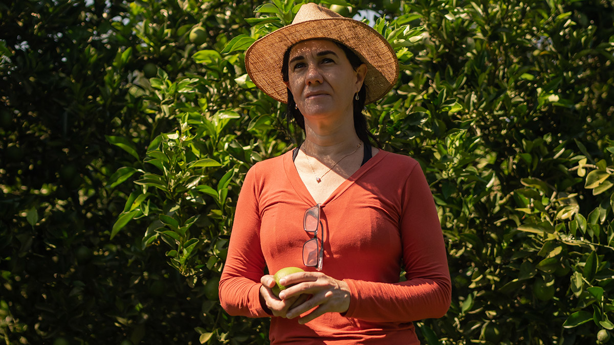 Sandra Zanardi con una de las naranjas de su finca. Fruto Resiliente. Foto: Avener Prado